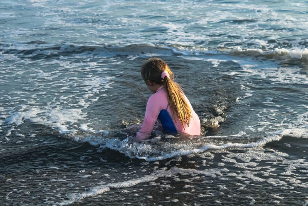 Kind in open water benadrukt waarom goed zwemonderwijs essentieel is voor waterveiligheid en verdrinkingspreventie.